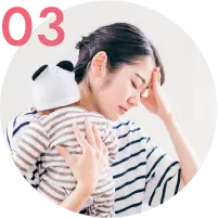 赤ちゃんを抱えて疲れた表情の母親