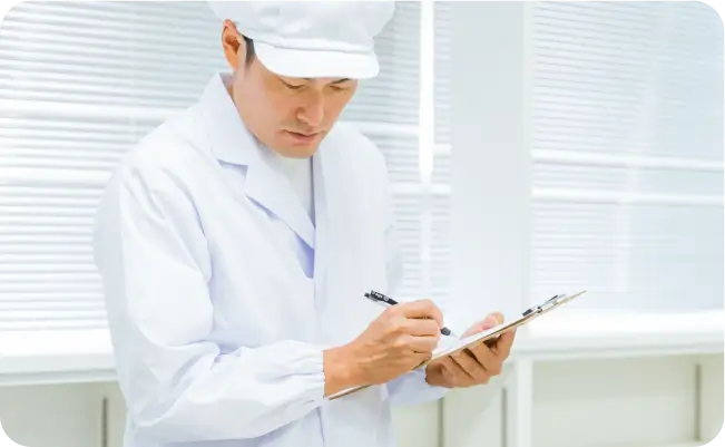 クリップボードに記入する白衣のスタッフ