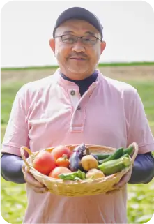 野菜を収穫してかごに入れた生産者