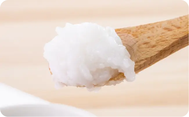 白いおかゆをすくった木のスプーン